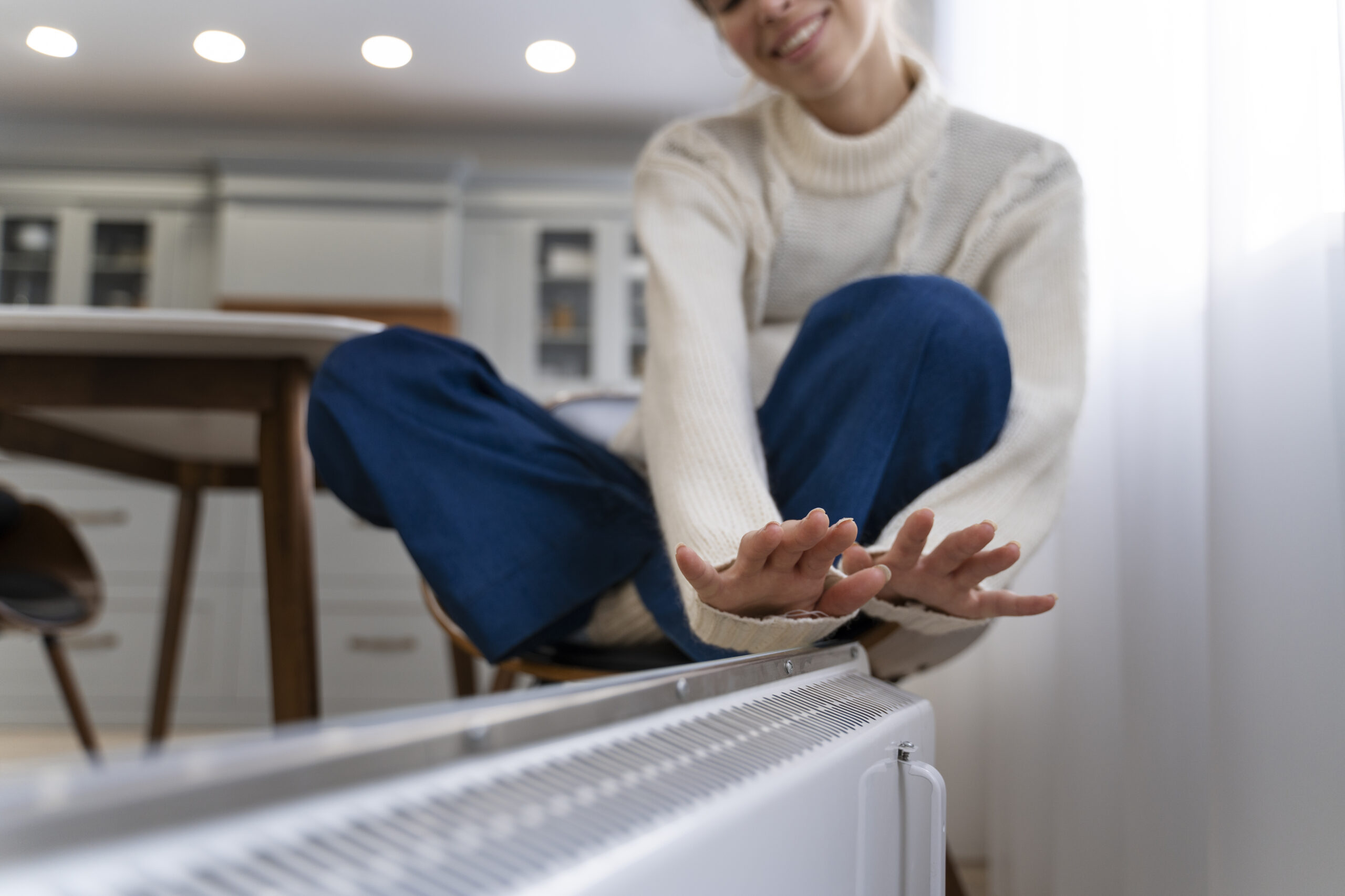 A woman touching a radiator installed by a Havant heating engineer.